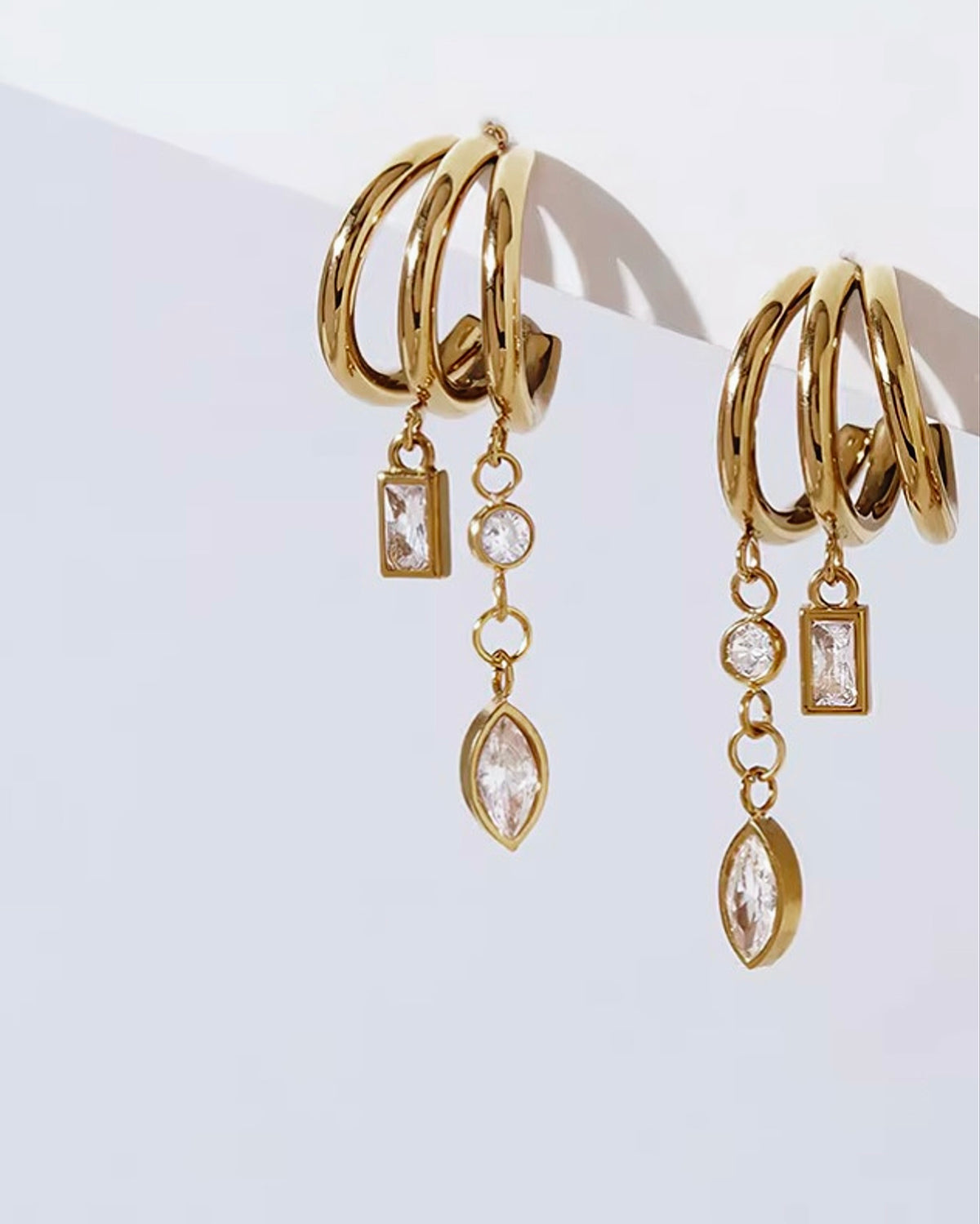 A triple-hoop silhouette with cascading chains and mixed-cut stones. Designed for bold dressers who want their earrings to make a statement. Shop Zorelle India.