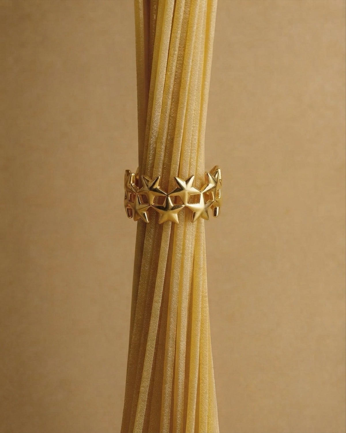 A pavé-set jaguar head with emerald-green eyes on an open band. Anti-tarnish, waterproof gold-tone stainless steel.