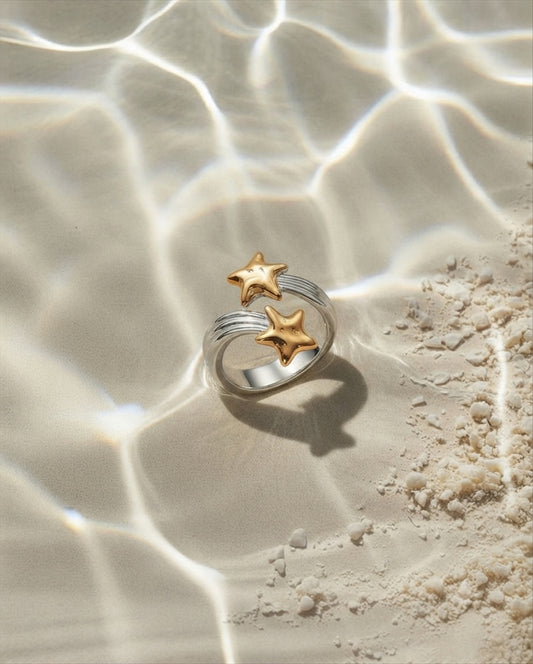 Twin gold stars trailing beams across a silver-tone wrap band. Anti-tarnish, waterproof gold-tone stainless steel. Shop Zorelle India.