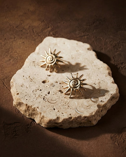 A sculptural sunburst with tapered rays around a textured orb. Anti-tarnish, waterproof gold-tone stainless steel. Shop Zorelle India.