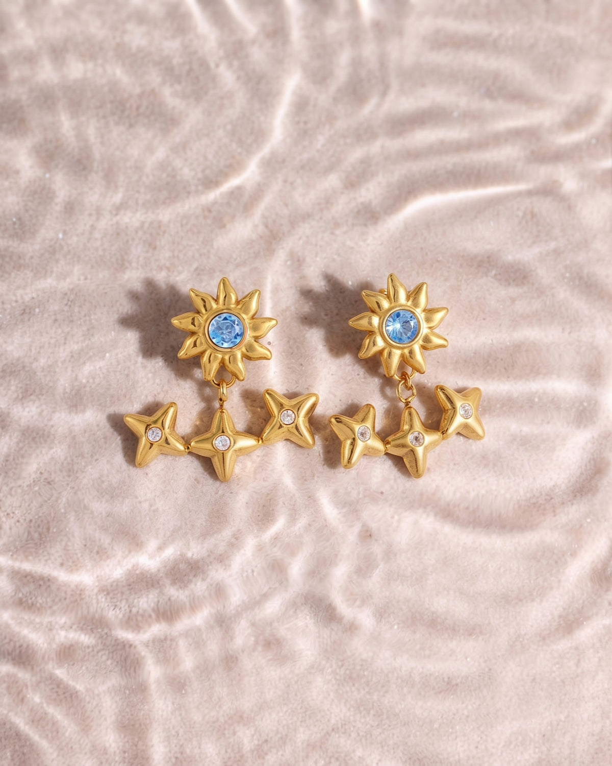 A crystal sunburst stud with a jacket of three stone-set stars below. Anti-tarnish, waterproof gold-tone stainless steel. Shop Zorelle India.