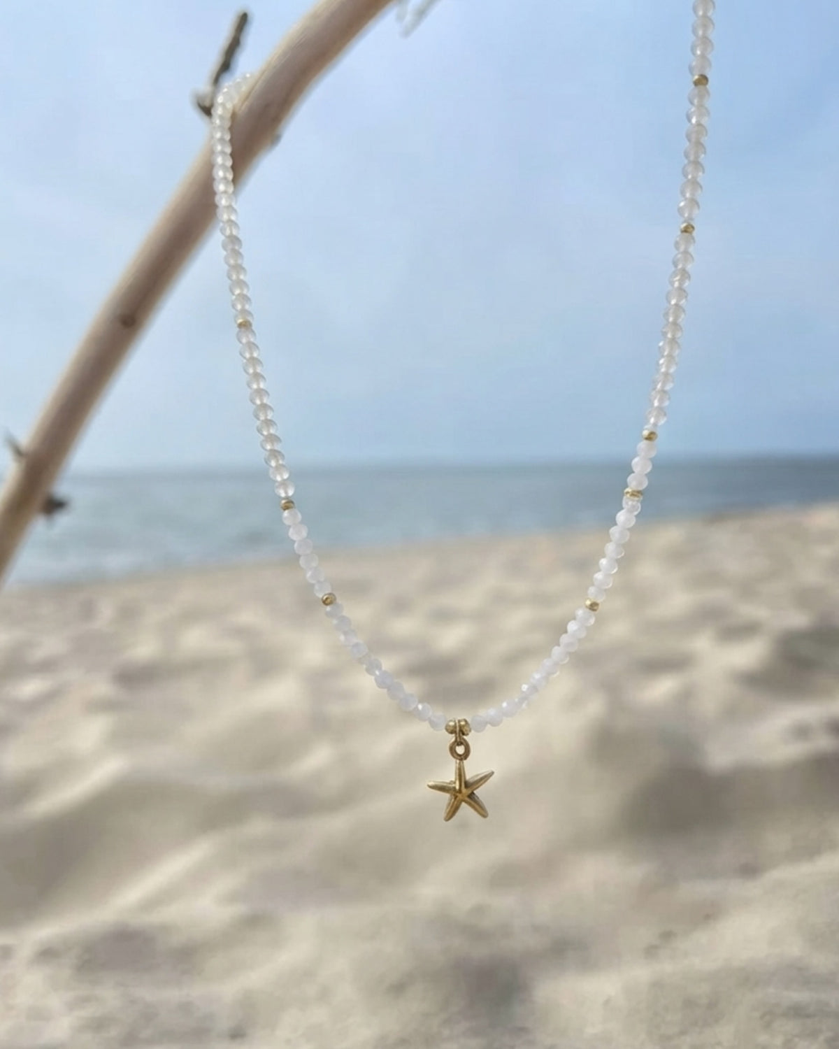 Translucent beads and gold accents holding a polished starfish charm. Anti-tarnish, waterproof gold-tone stainless steel. Shop Zorelle India.