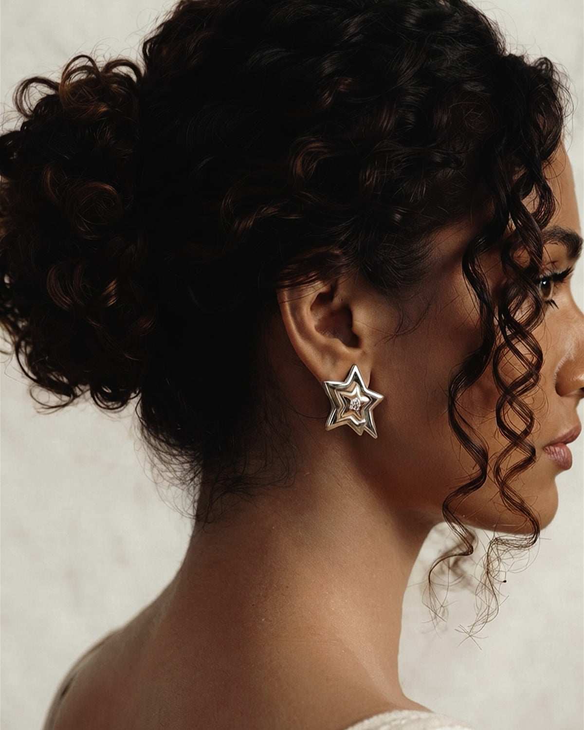 A silver-tone outer star framing a gold inner star and crystal. Designed for bold dressers who want their earrings to make a statement. Shop Zorelle India.